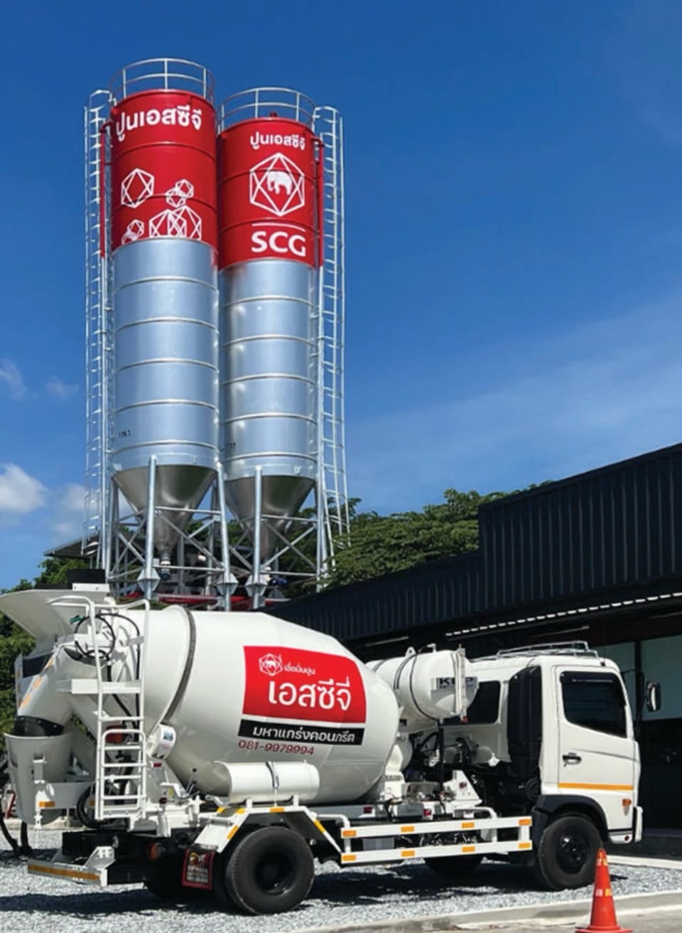 Red and white cement silos with a Mahakrang mixer at the plant